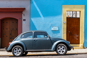 VW Beetle in front of colorful colonial architecture in Oaxaca i