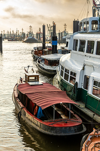 Historic boats in the museum harbor in Hamburg Övelgönne at the Elbe River at sunrise 