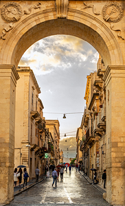 Beautiful baroque archway and people in the streets of Noto on Sicily in Italy 