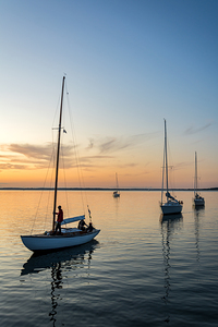 Sailing boats coming back into the harbour during beautiful sunset at the Baltic Sea in Northern Germany