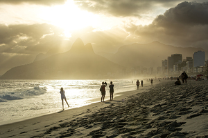 People enjoying dramatic sunset at Ipanema Beach in Rio de Janeiro 