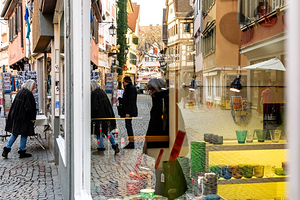 Street photo of reflections of people window shopping in the city 