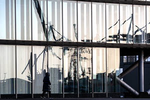 Harbor cranes reflecting in glass façade of modern building at the Elbe River in Hamburg 