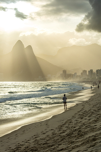 Man watching dramatic sunset at Ipanema Beach in Rio de Janeiro in Brazil