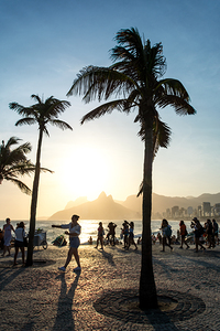 People at the promenade of Ipanema Beach in Rio de Janeiro in Brazil at sunset  