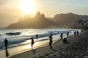 People enjoying the ocean during beautiful sunset at Ipanema Beach in Rio de Janeiro 