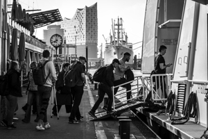 Black and white shot of people entering a ferry at St. Pauli Landungsbrücken in Hamburg