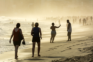 People strolling at Ipanema Beach in Rio de Janeiro in Brazil at sunset  