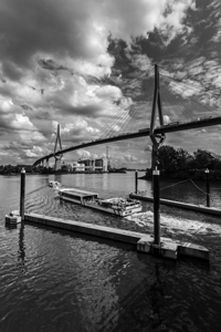 Black and white shot of the Köhlbrandbrücke and ferry in Hamburg