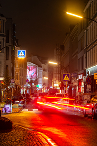 Long exposure night shot of a colourfully illuminated street and zebra crossing in Hamburg Altona