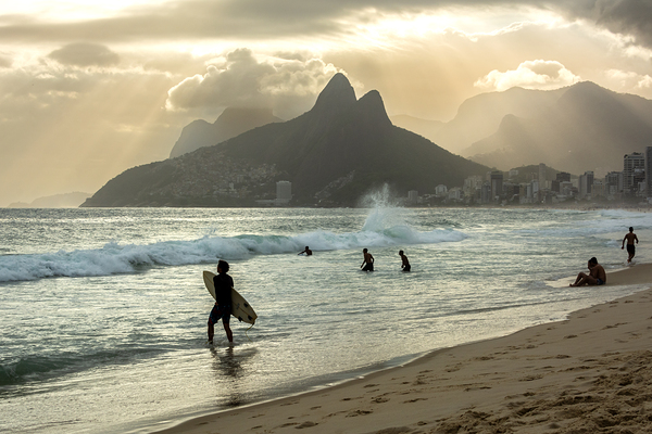 Surfer walking into the ocean at Ipanema Beach in Rio de Janeiro in Brazil at sunset Print