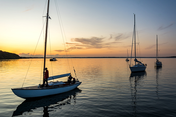 Sailing boats coming back into the harbour during scenic sunset at the Baltic Sea in Northern Germany Print