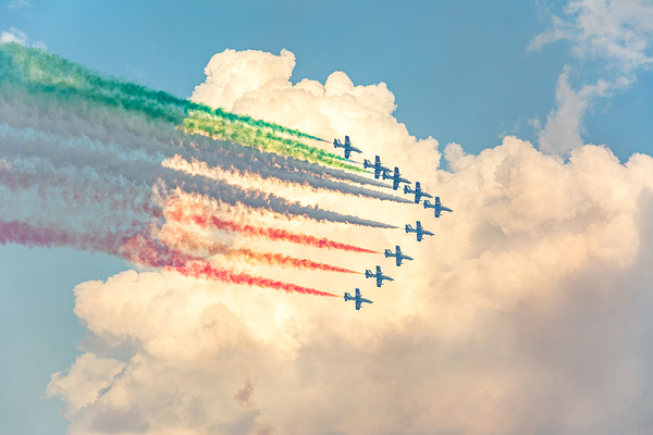 Fighter jets performing airshow with colorful exhaust streams in scenic clouds Print