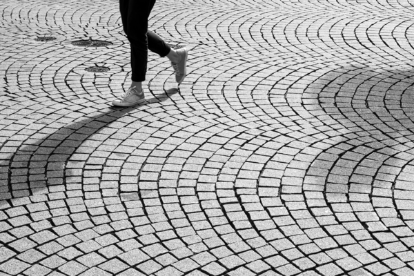 Street scene of a person walking on cobblestone  by caladoart
