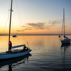 Sailing boats coming back into the harbour during scenic sunset at the Baltic Sea in Northern Germany