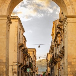Beautiful baroque archway and people in the streets of Noto on Sicily in Italy 