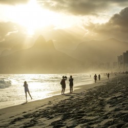 People enjoying dramatic sunset at Ipanema Beach in Rio de Janeiro 