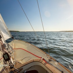 View from a sailing yacht sailing on the Baltic Sea during beautiful sunset 