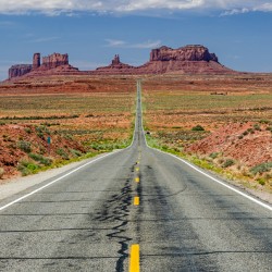Desert road leading towards Monument Valley in the USA