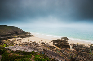 Beach with rocks and cloudy dark sky