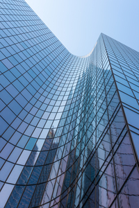 Blue curved glass skyscraper facade against sky 2