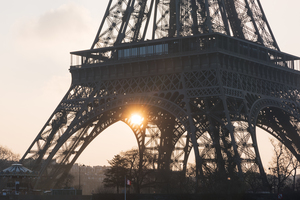 Eiffel tower close up against sun at sunrise