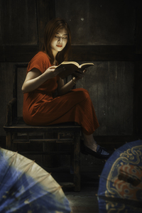 Young Chinese woman reading in an old house