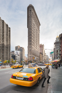 Young blonde woman getting out of a taxi in front of Flatiron building