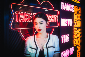 Young chinese woman standing next to neon lights
