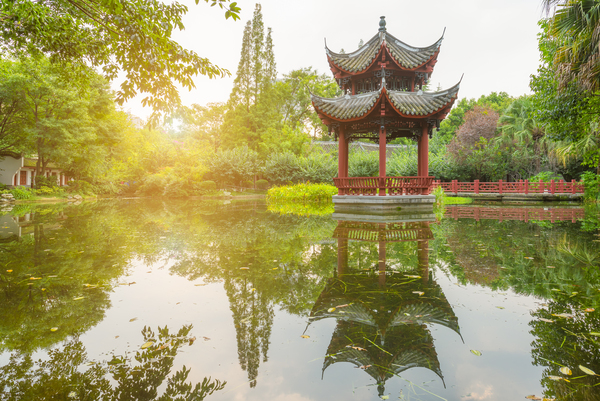 Chinese pavilion reflecting in a pond in BaiHuatan park by Philippe Lejeanvre