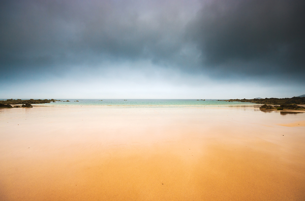 Empty beach and dark sky by Philippe Lejeanvre