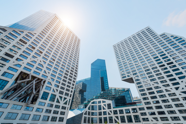 Modern buildings against blue sky and sun by Philippe Lejeanvre