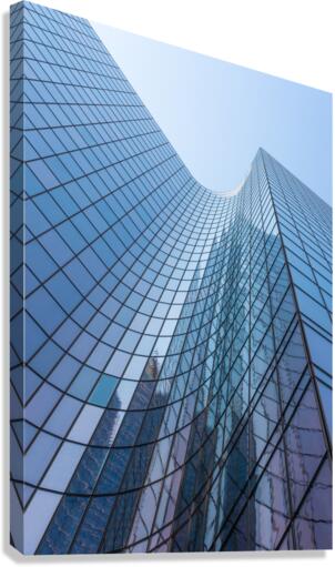 Blue curved glass skyscraper facade against sky Canvas Print