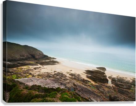 Beach with rocks and cloudy dark sky Canvas Print