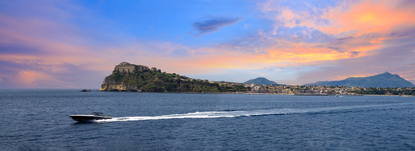 Italy scenic sunset over Procida Island near Naples with boat a by Elijah Lovkoff