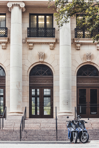 Blue scooters parked in front of an old building Print