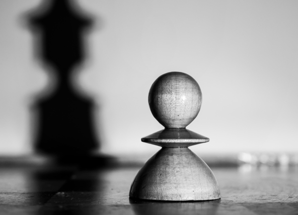 A single white pawn on a chessboard with kings shadow by Jurica Tomic Svarun