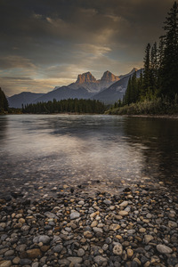 Soft orange sunset over The Three Sisters in Canmore.
