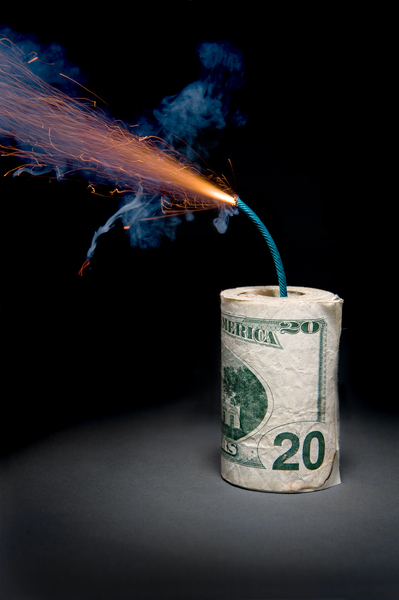Dynamite cash with lit fuse by Joe Belanger