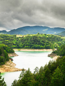 Stunning Mountain Lake Surrounded by Dense Forest and Rolling Hills