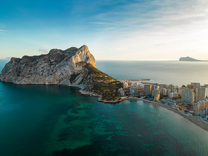 Aerial drone view of Calpe city. View of Ifach Mountain. Beautiful sunset colours