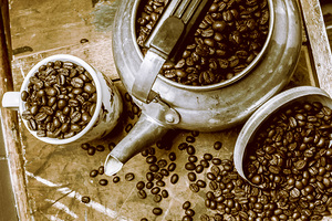 Roasted coffee beans in kettle and cup
