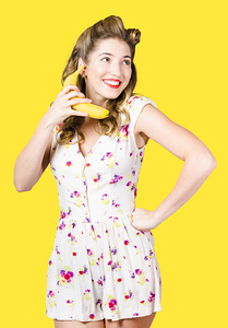 Retro pin up girl chatting on banana telephone
