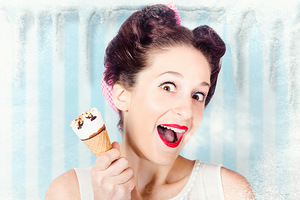 Cool pin-up woman in cold freezer with ice-cream