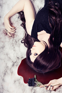 Dead woman holding black flower in blood puddle