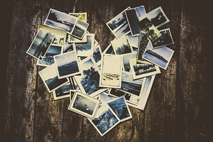 Heart-shaped instant photographs on wooden background