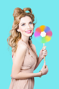 Blonde girl holding windmill fan. Natural energy