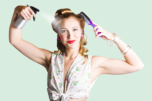 Isolated woman styling her hair on white
