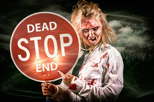 Halloween portrait. Scary zombie holding stop sign