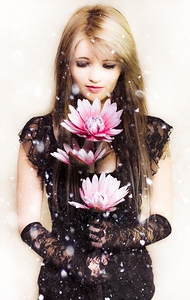 Beautiful young woman holding a delicate flower